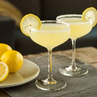 Two Vodka Sidecar cocktails in coupe glasses with sugar rims and lemon wheel garnishes