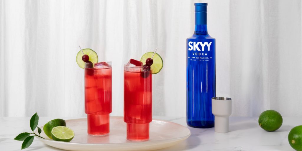 Two SKYY Vodka Cranberry cocktails with fresh lime and cranberry garnish