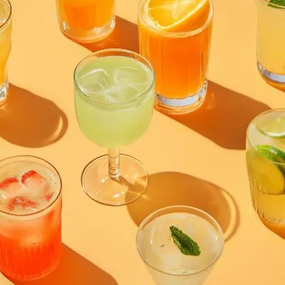 Top view of a selection of vegan cocktails on an orange surface