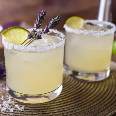 Two Lime Margaritas with lavender garnish