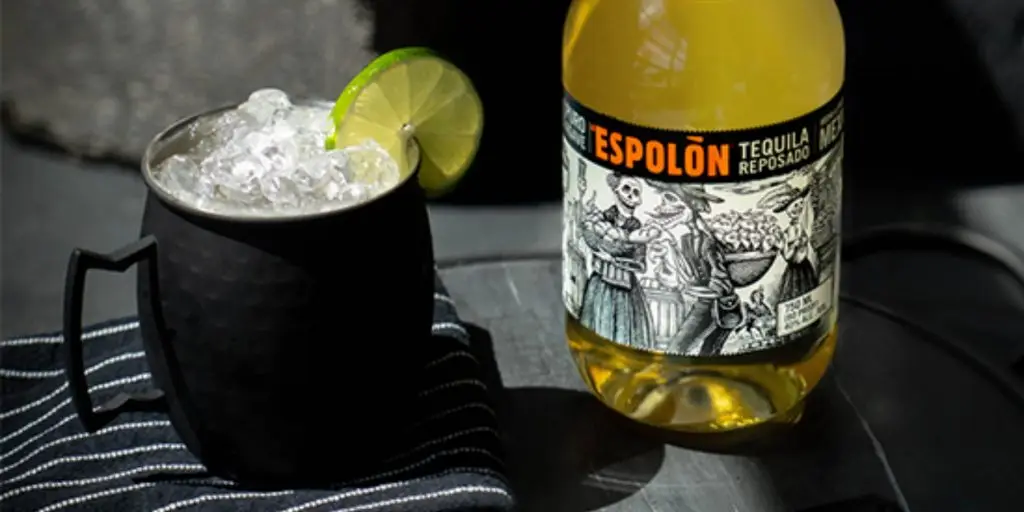 An Espolòn Spicy Mule cocktail in a black copper mug with lime garnish 