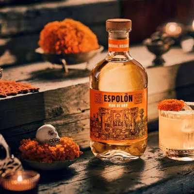 A bottle of Espolòn Flor de Oro next to a Marigold Margarita for Día de Muertos