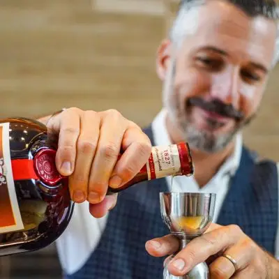 Headshot of Xavier Herit, pouring Grand Marnier into a jigger