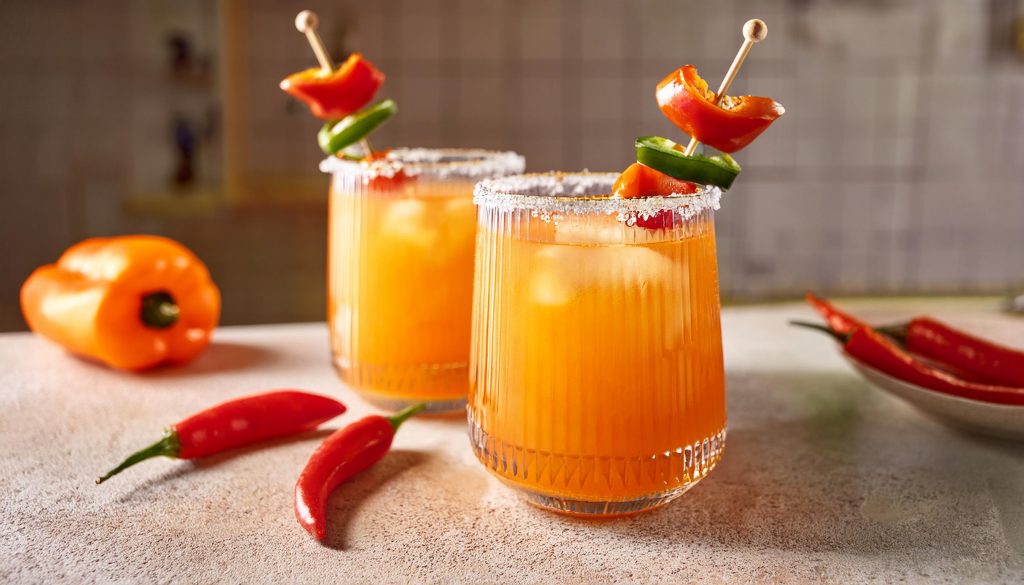 Two Salsa Sunset Savory Cocktails with bell pepper and jalapeño garnish