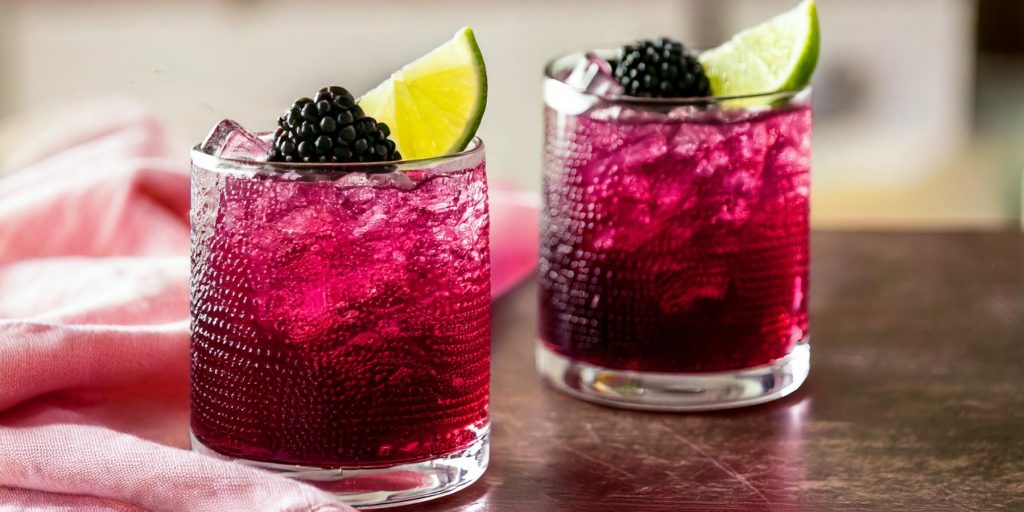 Two Blackberry Paloma Mocktails with fresh blackberry and lime garnish